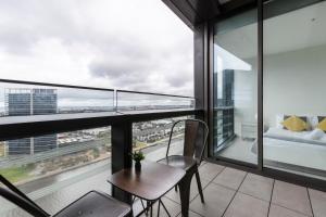 a balcony with a table and chairs and a view of the city at KULA Docklands in Melbourne