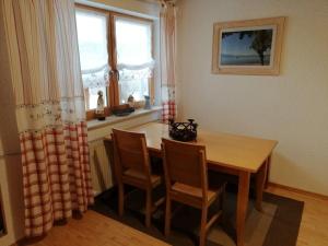 ein Esszimmer mit einem Tisch, Stühlen und einem Fenster in der Unterkunft Ferienwohnung Kurtz in Teisendorf