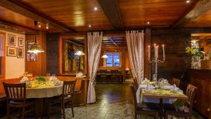 comedor con mesas y sillas en una habitación con techos de madera en Swiss Lodge Joopi, en Reckingen - Gluringen