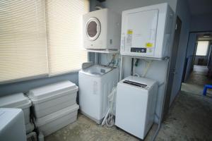 a laundry room with washer and dryers and a microwave at La Union ラウニオン in Fukushima