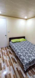a bed in a room with a wooden floor at Aparta estudio cerca al aeropuerto espectacular in Bogotá