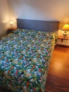 - une chambre avec un lit et une couverture colorée dans l'établissement L'Amirade, à La Désirade