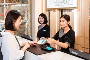 three women standing at a counter in a store at Hotel Ch&acirc;teau Anping in Tainan