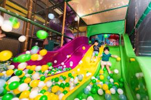 台南的住宿－夏都城旅安平館，两个孩子在充满球的室内游戏室玩耍