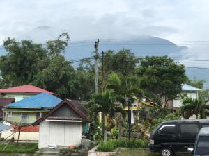 una furgoneta estacionada frente a una casa con una montaña en Muda Raya Homestay, en Kotabaru