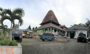 un bâtiment avec des voitures garées dans un parking dans l'établissement Muda Raya Homestay, à Kotabaru