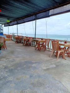 a row of tables and chairs with the ocean in the background at Suhaila Palace in Perhentian Islands +19 photos