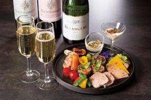 a plate of food and two glasses of wine at The Royal Park Hotel Iconic Tokyo Shiodome in Tokyo
