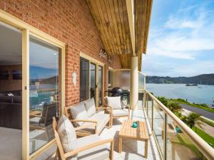 a balcony with chairs and a table on a building at Grand Pacific 2 Unit 4 -Omaroo - First Floor in Narooma