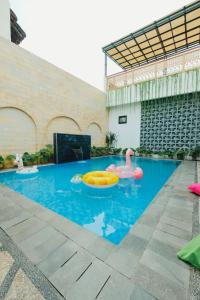 a swimming pool with two inflatables in a building at Villa Ruang Rindu Malioboro in Sentool