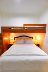 a bedroom with a large white bed with two lamps at Villa Ruang Rindu Malioboro in Sentool