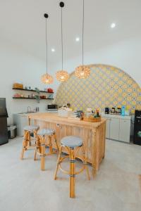a kitchen with a wooden counter and two stools at Villa Ruang Rindu Malioboro in Sentool