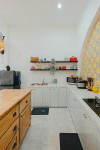 a kitchen with white cabinets and a counter top at Villa Ruang Rindu Malioboro in Sentool