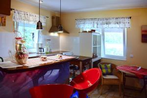 a kitchen with a table and red chairs in a kitchen at Bungalow, Bieszkowice in Bieszkowice