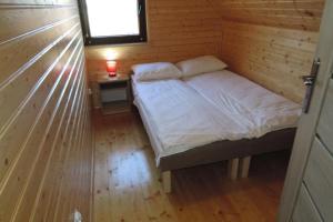 een kleine slaapkamer met een bed in een houten hut bij Modern wood House in Rewal with a terrace in Rewal
