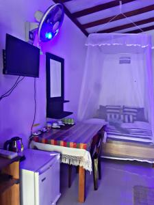 a purple room with a table and a bed at Cozy Homestay Waterfall Road Ella in Ella