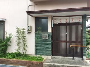 een huis met een poort en een deur bij Guesthouse Hakuka in Kanazawa