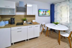 a kitchen with white cabinets and a table and chairs at Apartment in Kolobrzeg with parking space in Kołobrzeg