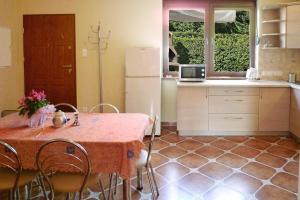 a kitchen with a table and chairs and a refrigerator at Semi-detached house, Rowy in Rowy