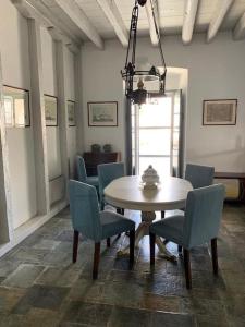 a dining room with a table and blue chairs at Villa 1853, Spetses Ground Floor in Spetses