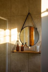 a mirror on a shelf in a bathroom at Kezlyn Farm Cottages in Bergville