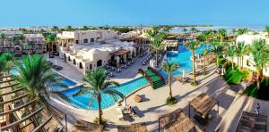 an aerial view of a resort with a pool and palm trees at Jaz Makadina in Hurghada