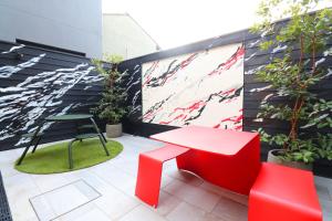 un patio con banco rojo, mesa y sillas en Travelodge Kyoto Shijo Omiya, en Kioto