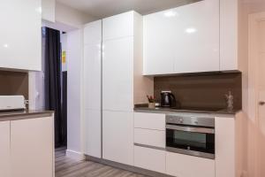 a kitchen with white cabinets and a stove at Lugar especial, gran patio, junto al ayuntamiento in Bilbao