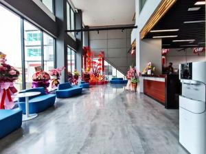 a lobby with blue chairs and flowers in a building at Starlink Hotel in Sibu