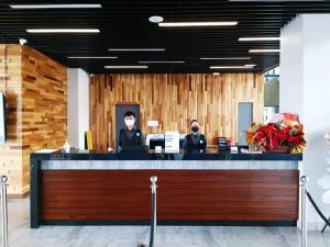 two people wearing masks at a counter in a lobby at Starlink Hotel in Sibu