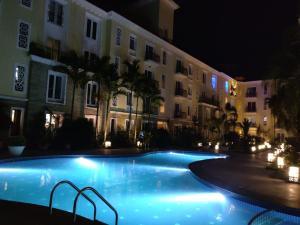 a swimming pool in front of a building at night at Studio Apartment by Leela Homes in Arpora +33 photos