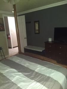a bedroom with a large bed and a television at Curt's cozy room rentals in Wendover