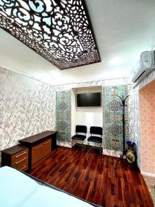 Zimmer mit 2 Stühlen, einem Schreibtisch und einem Bett in der Unterkunft Colibri Traditional Guest house in Samarkand