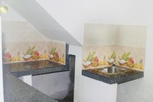 a bathroom with a sink and a counter with desserts at Sunshine Guest in Madihe East