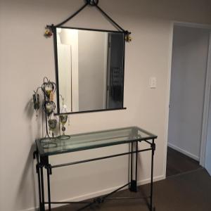 uma mesa de vidro com um espelho na parede em Tiwai Waka Retreat em Wellington