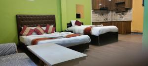 duas camas num quarto com paredes verdes em Nepalaya Hotel em Kathmandu