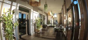 アプトにあるL'Aptois Hôtelの廊下にテーブルと鉢植えのレストランがあります。