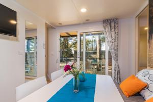 una sala da pranzo con tavolo e vaso di fiori di Peputo Luxury Residence & Mobile Homes a Rovigno (Rovinj)