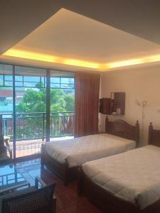 a bedroom with two beds and a balcony at Kamala bay inn in Kamala Beach