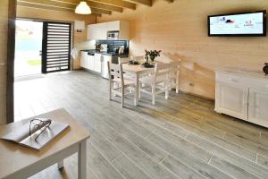 a kitchen and living room with a table and a tv at Comfortable holiday homes, sauna, Sianozety in Sianozety