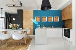 uma cozinha com uma mesa de jantar e uma parede azul em Holiday complex, Ustronie Morskie em Ustronie Morskie