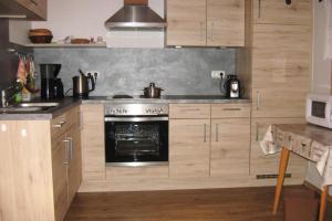 a kitchen with wooden cabinets and an oven at Blockhaus in Rinchnach mit Panoramablick in Rinchnach