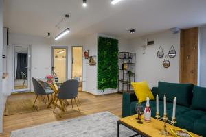 a living room with a green couch and a table at Гардън Апарт in Blagoevgrad +3 photos