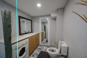 a bathroom with a toilet and a sink at Гардън Апарт in Blagoevgrad