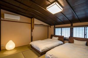 小浜市にあるOBAMA MACHIYA STAYのベッドルーム1室(ベッド2台付)、天井に照明が付いています。