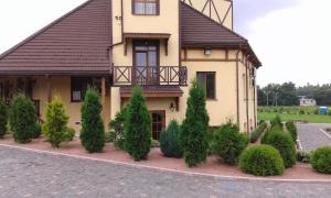 a house with a bunch of trees in front of it at Chalet Hotel in Zhytomyr