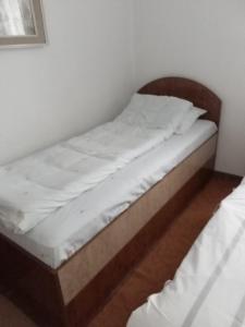 a bed with white sheets on it in a room at Apartman Marija in Zlatibor