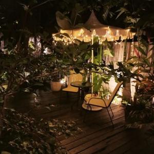 a patio at night with a table and chairs at Inn Oon Villa in Chiang Mai