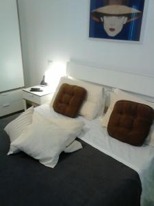 a bedroom with a bed with white sheets and brown pillows at Le Ciel d'Orphèe in Pisa