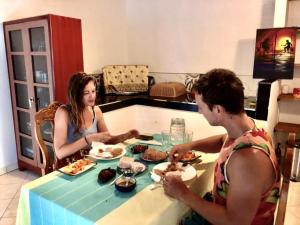 a man and a woman sitting at a table eating food at Thusitha s nest in Dickwella +25 photos